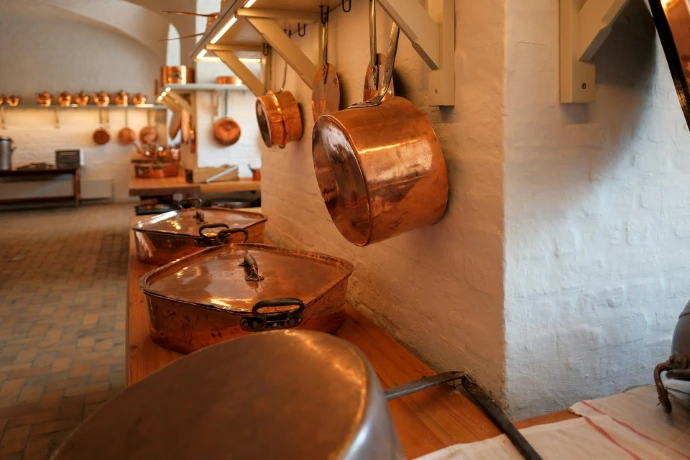 brass cookware hanging near wall in kitchen area